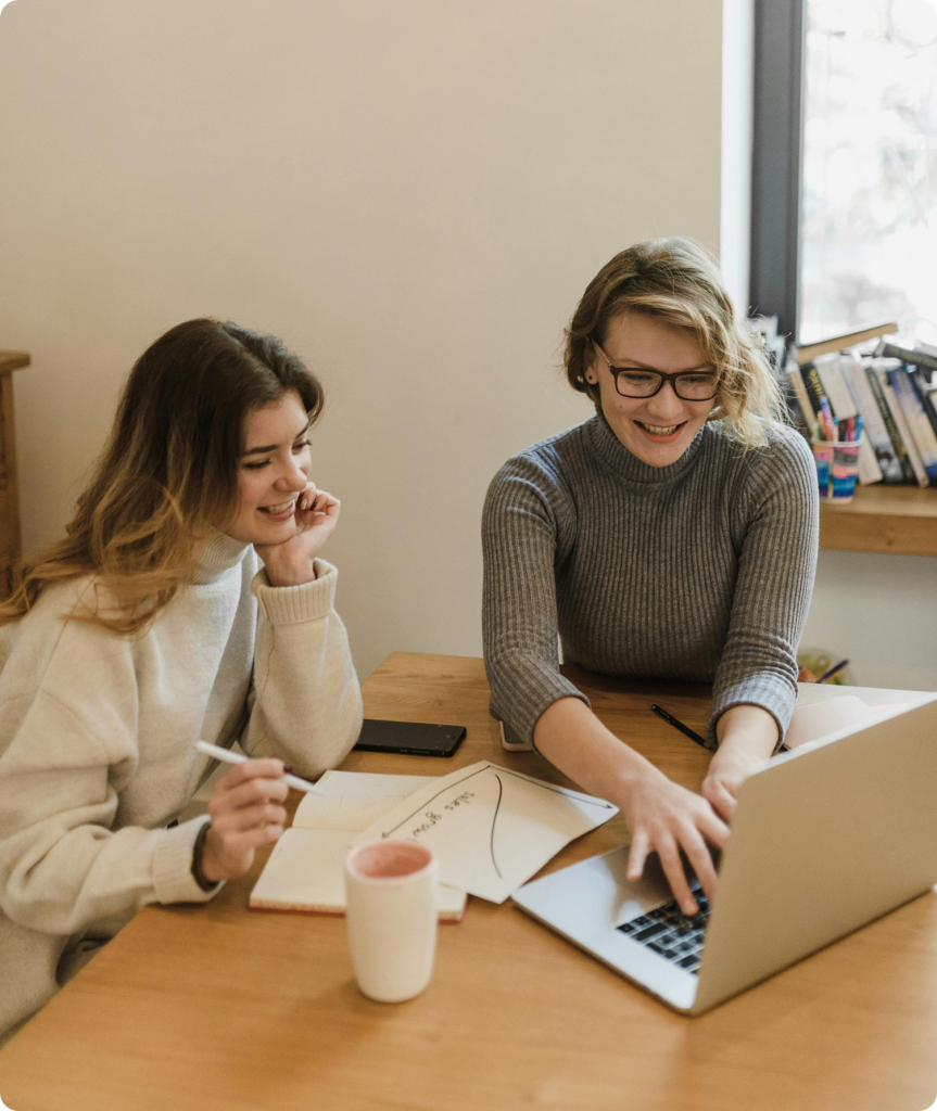 Women collaborating at laptop during coaching session